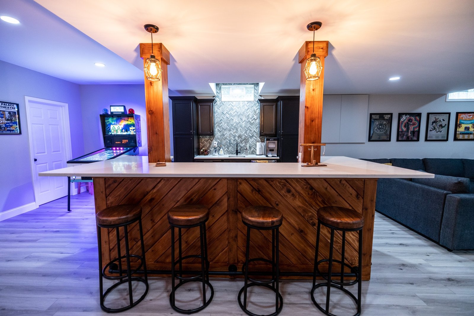 Finished basement with a custom cedar bar, quartz top, pendant lights and an arcade games area